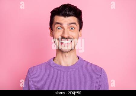 Photo of cute impressed young man dressed purple pullover smiling isolated pastel pink color background Stock Photo