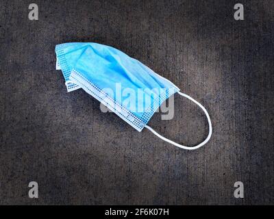 Discarded facemask face mask for Covid Coronavirus garbage trash Stock Photo