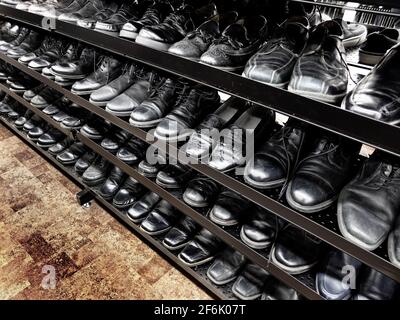 Rows of old mens men's dress shoes at thrift store on sale Stock Photo