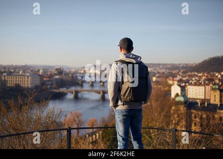 Man looking at cityscape at sunrise. Urban skyline with Charles Bridge in Prague, Czech Republic. Stock Photo