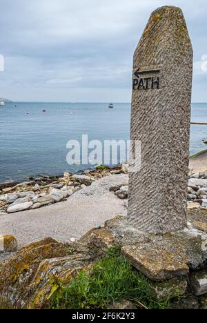 A stone marker for a coastal path along the shoreline on the South coast of England Stock Photo