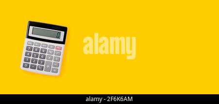 calculator with gray and black buttons on a yellow background. Conceptual photo of calculations, accounting, computing, profit, loss, tax with place f Stock Photo