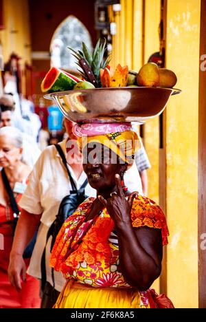 Cartagena, Colombia, Old Walled City Center centre, Centro, Playa de las Bovedas, shopping arcade. Woman in traditional costume selling fruit in the h Stock Photo