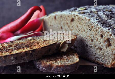 Multigrain Bread with Flax Seeds and Sesame on Wooden Board. Stock Photo