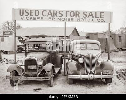 Used cars for sale with signs and prices at service station on