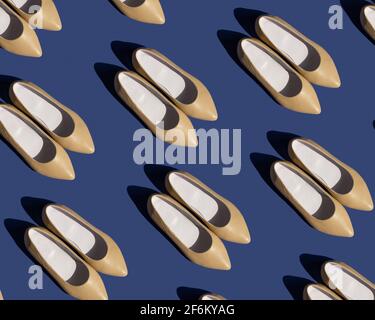 Pattern of women's beige leather shoes on a blue background. Stock Photo