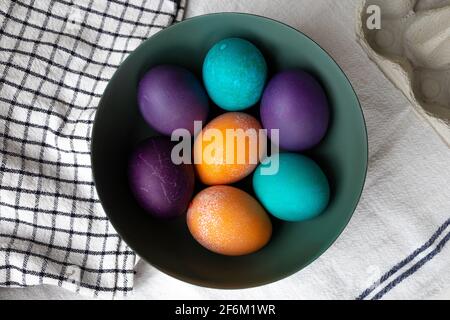 Easter eggs in a bowl in blue, turquoise, purple, and orange. Stock Photo