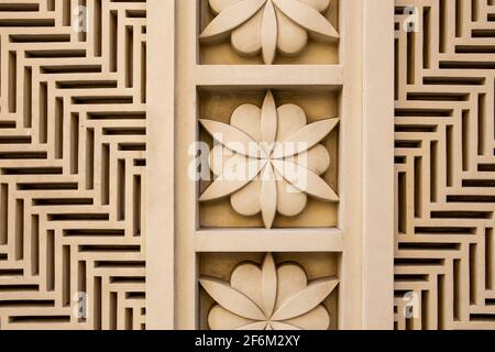 Arabic style carved stone openwork and relief, with floral patterns and geometric shapes and lines, on a building facade in Dubai JBR, UAE. Stock Photo
