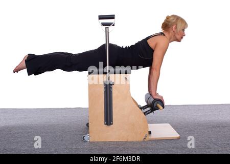 A 50-year-old trainer practices Pilates on an elevator chair