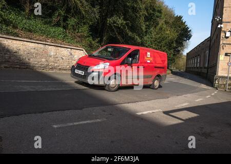 Red Royal Mail delivery van on a road outside an industrial estate. Stock Photo