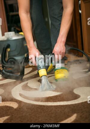 Cleaning company worker cleans the carpet in a recreation area Stock ...