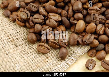 Coffee beans on sacking bag on desk with place for you text. Stock Photo