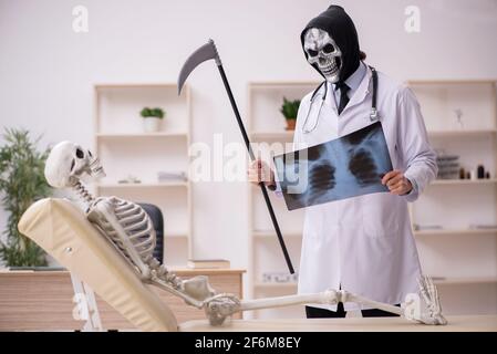 Devil doctor radiologist examining skeleton patient at the hospital Stock Photo