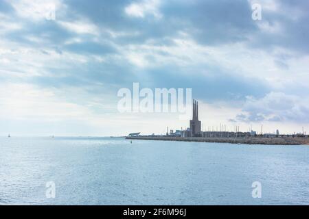 Seascape in the Mediterranean Sea with views of an old disused Thermal Power Plant for the production of electricity in Barcelona Stock Photo