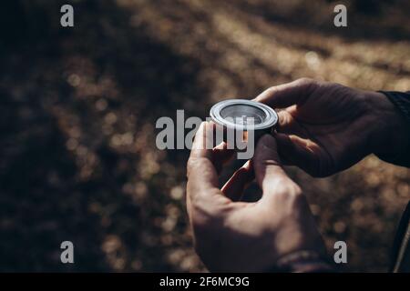 Man using compass in forest Stock Photo