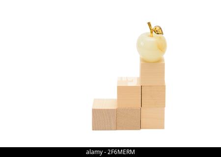 Ladder made of wooden cubes. On top step is figure of apple. Award concept, business. Isolated over white background. Stock Photo