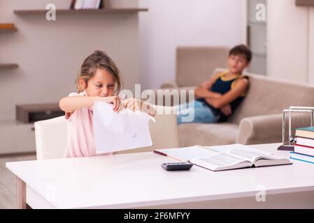 Teenager and his small sister staying at home during pandemic Stock Photo