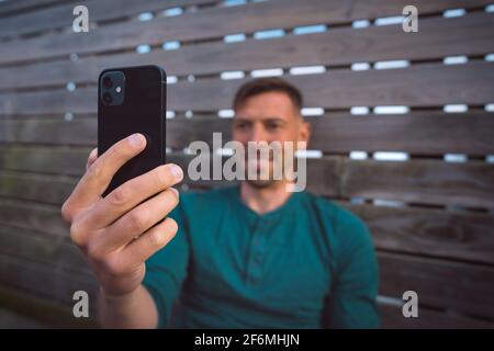 Man using mobile phone. Looking at smartphone and having a facetime video call Stock Photo
