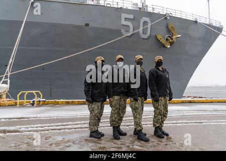 U.S. Navy commanding officers from left to right: Cmdr. Kimberly Jones, Cmdr. LaDonna M. Simpson, Cmdr. Kathryn Wijnaldum, and Cmdr. Kristel O'Canas, pose in front of the Harpers Ferry-class amphibious dock landing ship USS Carter Hall January 28, 2021 in Virginia Beach, Virginia. The group are the first four women of color to command warships in the U.S. Navy. Stock Photo