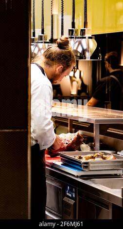 a working young man in a restaurant kitchen. Stock Photo