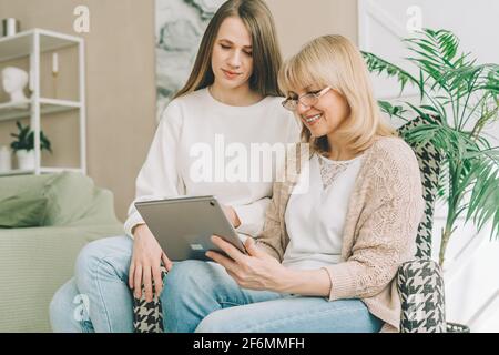 Mother and adult daughter using digital tablet Stock Photo