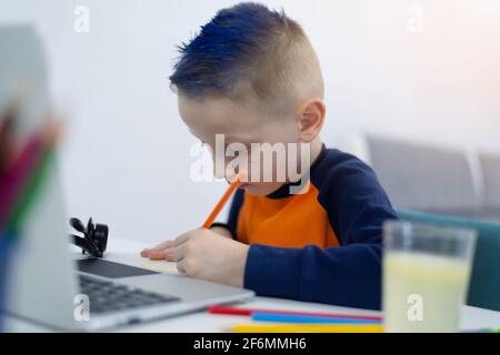 Distance learning and online education. Schoolboy boy studies at home and does school homework. Remote learning during corona pandemic Stock Photo