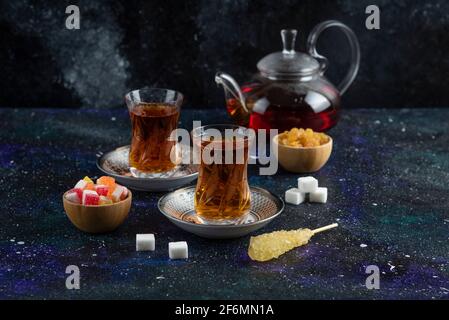 Fragrant tea with candies on blue background Stock Photo