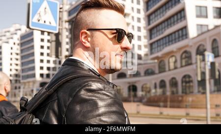 An attractive man wearing black leather jacket with dark sunglasses Stock Photo