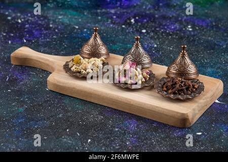 Different herbs and spices on wooden board Stock Photo