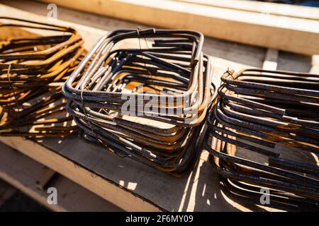 Close up on the construction armature iron frames on the other building material at the construction site in sunny day Stock Photo