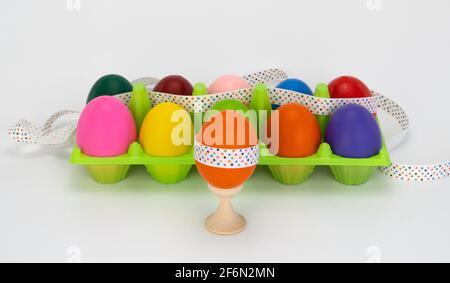 easter egg on a wooden stand. colorful eggs in box. plastic package. decorated with a festive ribbon. Stock Photo