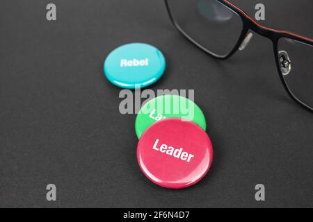 Colored plastic magnetic buttons on a black background next to glasses. Stock Photo