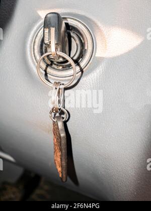 Key with a key fob in the ignition lock of a passenger car. Car ignition lock. Key with key fob. Engine starting. Start the engine. Vehicle. Driver pr Stock Photo