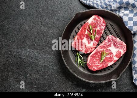 Fresh raw rib eye steaks on grill pan Stock Photo