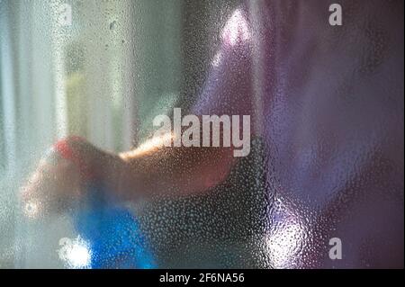 Midsection of woman holding window cleaner in a plastic bottle with spray Stock Photo