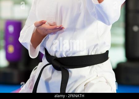 Woman in martial art training in a gym, she is wearing a black belt Stock Photo