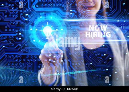 Business, Technology, Internet and network concept. Young businessman working on a virtual screen of the future and sees the inscription: Now hiring Stock Photo