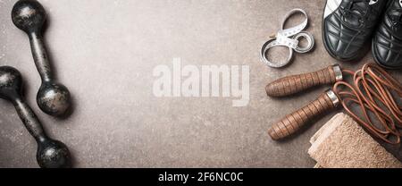 Fitness background with dumbbells, skipping rope, sneakers and towel Stock Photo