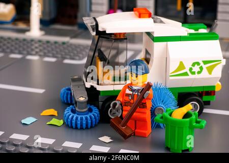 Tambov, Russian Federation - January 17, 2020 Lego cleaner minifigure with brush cleaning street near street sweeper truck. Studio shot. Stock Photo