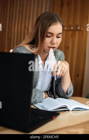 Copywriter, content creator, Remote Copywriting. Young woman freelancer typing on keyboard using laptop computer in cafe, office. Copywriter working Stock Photo