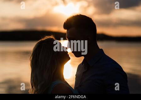 Silouette, loving couple on the lake during sunset Stock Photo