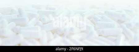 Long panoramic background with whites medical capsules. Top panoramic view, selective focus Stock Photo
