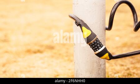 Combination lock near the post. Protection against theft of bicycles, scooters Stock Photo