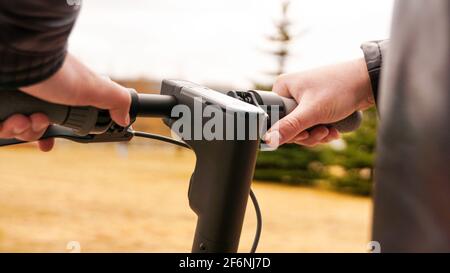 Close-up of male hand pressing speed button on electric scooter Stock Photo
