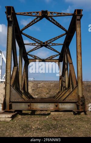 Rusty spans of the old railway bridge have been dismantled. Perspective photo taken on a sunny day. Stock Photo