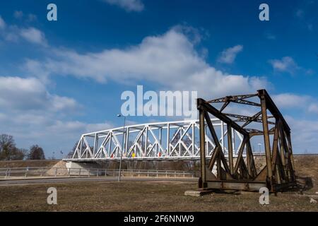 Rusty spans of the old railway bridge have been dismantled. Perspective photo taken on a sunny day. Stock Photo