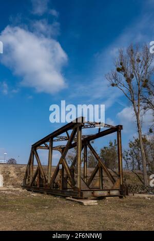 Rusty spans of the old railway bridge have been dismantled. Perspective photo taken on a sunny day. Stock Photo
