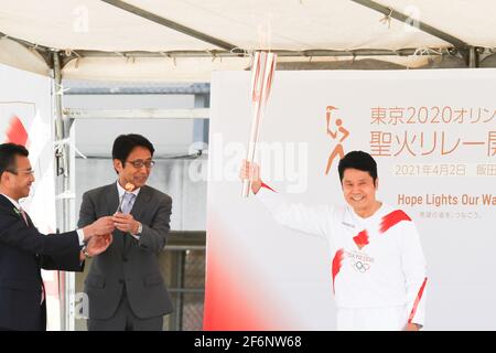 Iida, Japan, 02/04/2021, Olympic torch event in iida city. Runner and holder of the torch showing the lighted torch to the people. Stock Photo