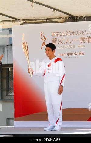 Iida, Japan, 02/04/2021, Olympic torch event in iida city. Runner and holder of the torch showing the lighted torch to the people. Stock Photo