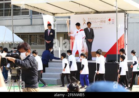 Iida, Japan, 02/04/2021, Olympic torch event in iida city. Runner and holder of the torch showing the lighted torch to the people. Stock Photo